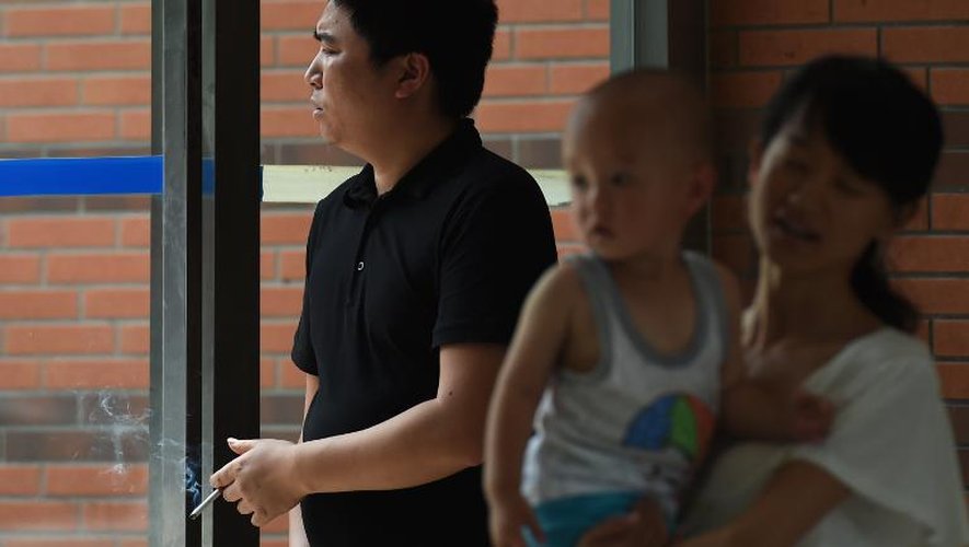 Un homme fume le 1er juin 2015 à l'entrée d'un hôpital pour enfants à Pékin