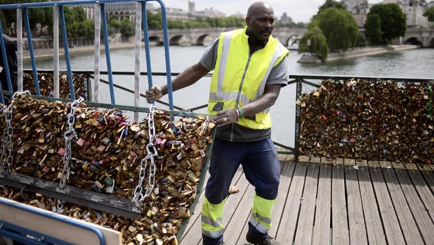 Un employé enlève les "cadenas d'amour" le 1er juin 2015 sur le Pont des Arts, à Paris