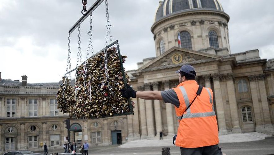 Un employé enlève les "cadenas d'amour", le 1er juin du Pont des Arts, le 1er juin 2015 à Paris