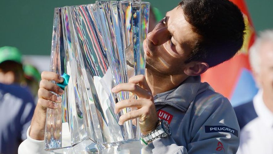 Novak Djokovic embrasse son trophée après sa victoire sur Roger Federer le 16 mars 2014 à Indian Wells