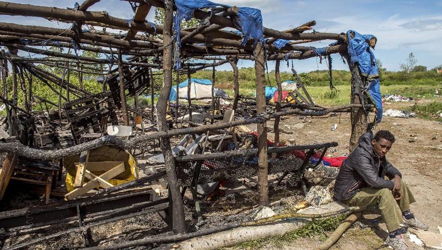 Un migrant assis près de son logement incendié, le 1er juin 2015 à Calais