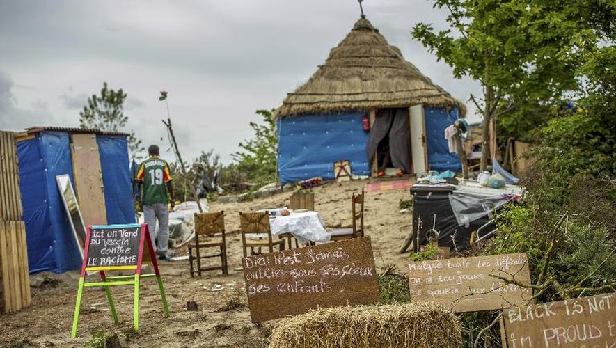 Des pancartes où sont inscrits "Vaccin contre le racisme en vente ici" (G) et "Malgré toutes les difficultés, nous avons toujours le sourire aux lettres" (2ème D), le 1er juin 2015 à Calais