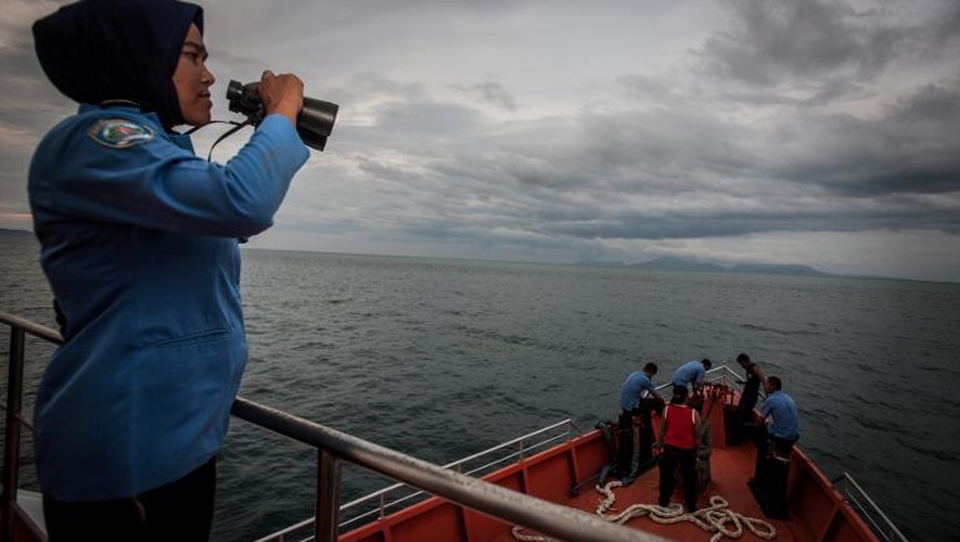 Un membre de l'équipe de secours et de recherche indonésienne scrute la mer d'Andama le 17 mars 2014