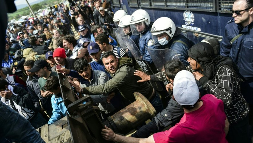 Des migrants tentent de percer une barricade installée par la police grecque à Idomeni, à la frontière avec la Macédoine, le 11 avril 2016