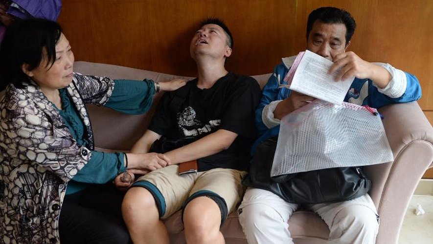 Des proches d'une victime du naufrage d'un navire de croisière sur le Yangtsé bouleversé par la nouvelle, près d'une agence de voyage à Shanghai, le 2 juin 2015