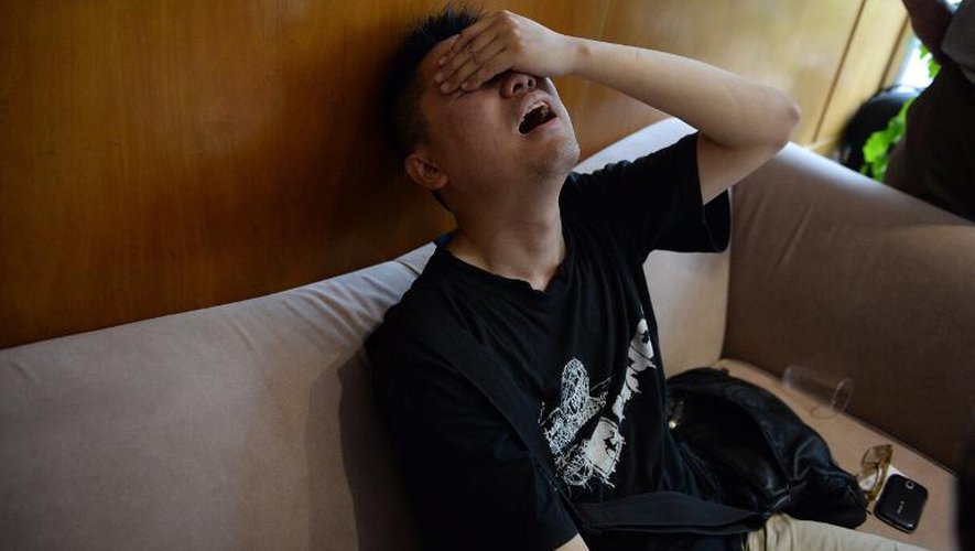 Un proche d'une victime du naufrage d'un navire de croisière sur le Yangtsé bouleversé par la nouvelle, près d'une agence de voyage à Shanghai, le 2 juin 2015