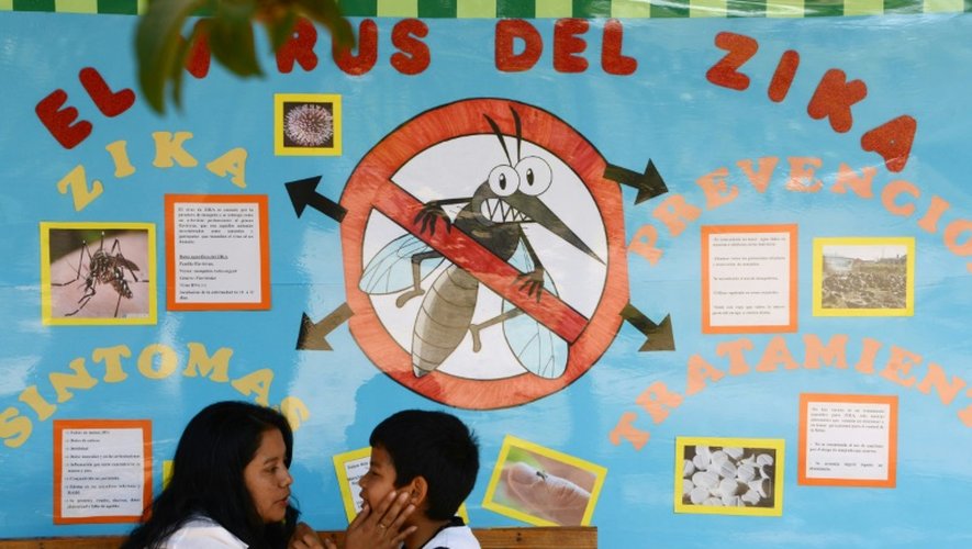 Une mère et son enfant devant un panneau expliquant le virus de Zika, à Tegucigalpa, au Honduras, le 26 février 2016