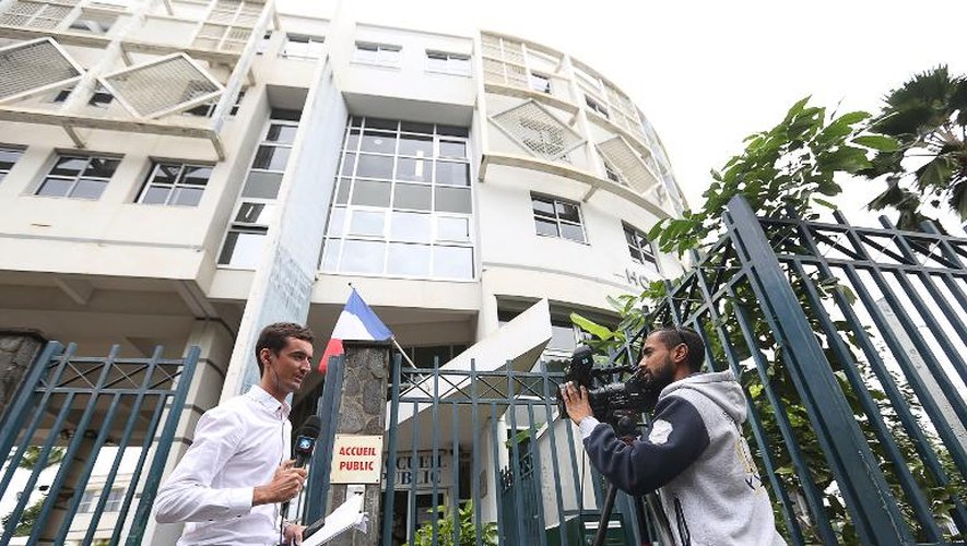 Entrée du commissariat central de Saint-Denis à La Réunion le 2 juin 2015, où un cameraman filme un journaliste relatant l'arrestation d'un groupe présumé de jihadistes