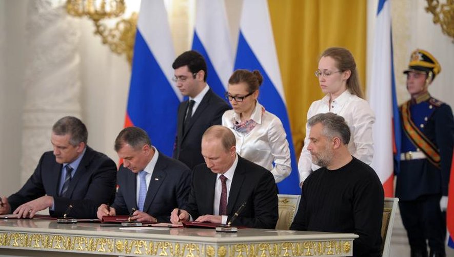Le président russe Vladimir Poutine signe avec les responsables actuels de la Crimée un traité rattachant la péninsule à la Russie, à Moscou le 18 mars 2014