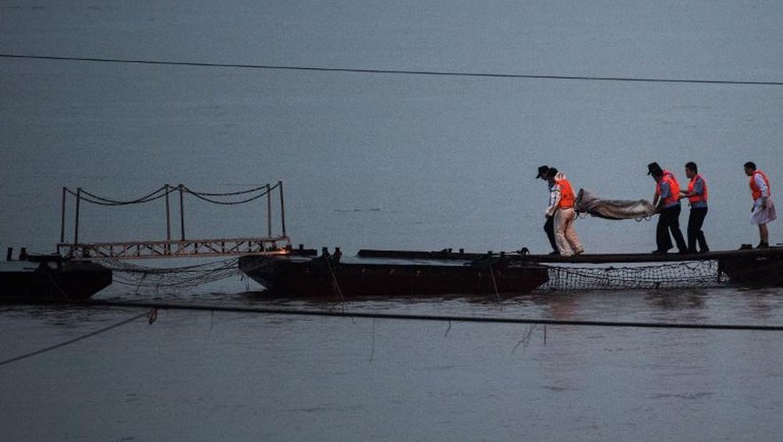 Des sauveteurs portent le cadavre d'un passager du bateau naufragé à Jianli le 2 juin 2015