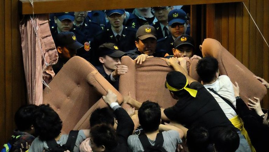 Des policiers tentent de pénétrer dans le parlement taïwanais, occupé par environ 200 étudiants et militants, à Taipei le 19 mars 2014