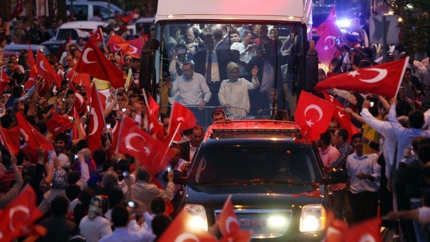 Erdogan et sa femme Emine entourés saluent leurs partisans le 9 juin 2013 à leur arrivée à Ankara