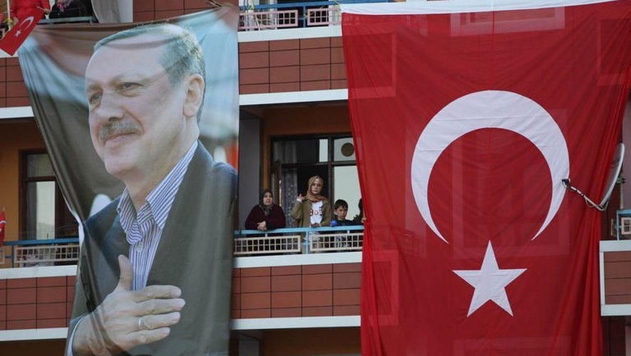 Des partisans du Premier ministre Recep Tayyip Erdogan pris entre son portrait et le drapeau national turc, le 9 juin 2013 à Ankara