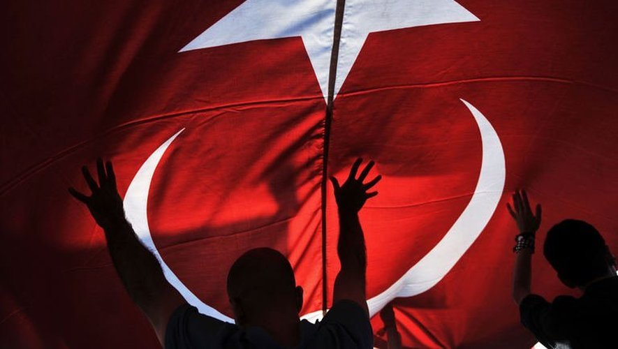 Des opposants au gouvernement tiennent le drapeau national turc à Izmir, le 9 juin 2013