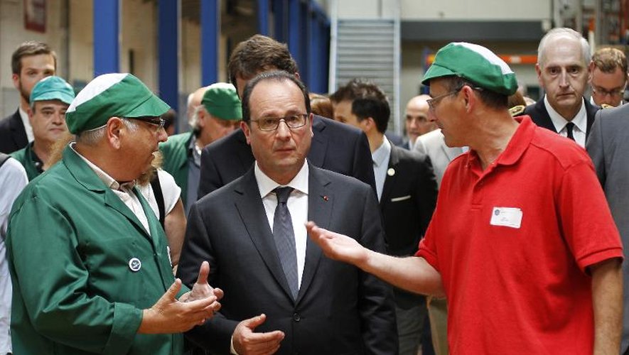 Le chef de l'Etat François hollande (c) écoute le 4 juin 2015 deux employés de la nouvelle société coopérative ouvrière provençale de thés et infusions, la Scop-Ti, ex-Fralib