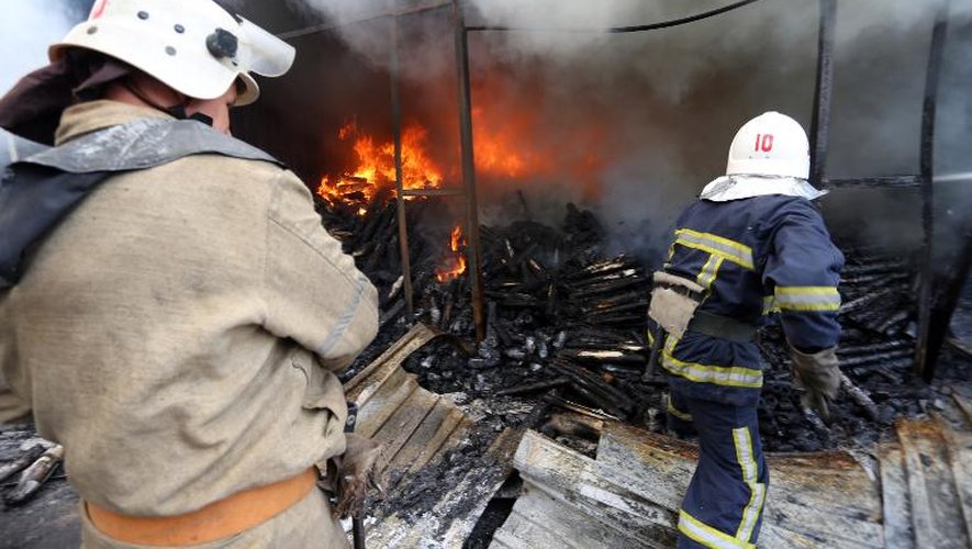 Des pompiers éteignent le 3 juin 2015 un incendie dans un marché de Donetsk, dans l'est de l'Ukraine, provoqué par les combats entre l'armée et les forces séparatistes prorusses