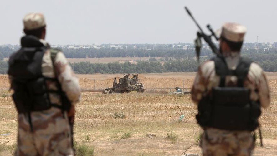 Des militants des brigades Ezzedine al Qassam, la branche militaire du mouvement palestinien Hamas, observent un bulldozer israélien le long des barbelés qui séparent Israël de Gaza près de Rafah, dans le sud de la bande, le 3 juin 2015
