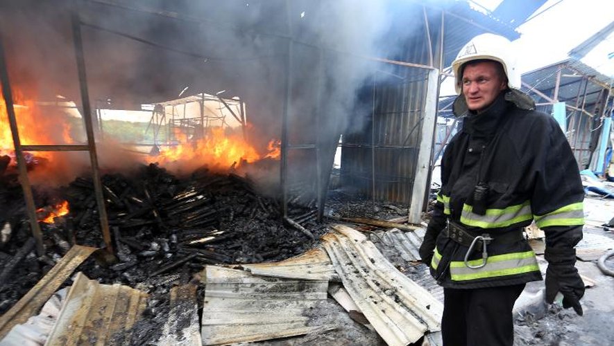 Des pompiers éteignent un incendie dans un marché de Donetsk, provoqué par les combats entre l'armée et les forces séparatistes prorusses, le 3 juin 2015