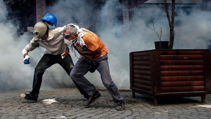 Des manifestants fuient les gaz lacrymogènes tirés par la police sur la place Taksim à Istanbul, le 11 juin 2013