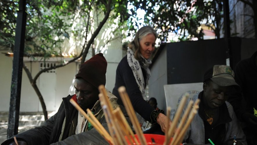 L'artiste australienne Lenore Boyd (c) accueille des enfants des rues à la mission des Frères de la charité de Pangani, dans le quartier pauvre "mlango-kubwa" de la capitale kényane Nairobi, le 11 décembre 2015