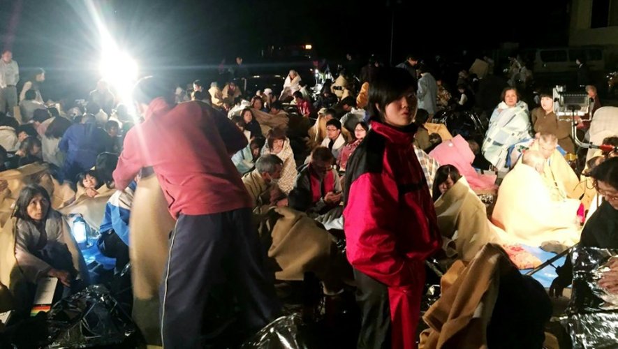 Des gens se réunissent dans un abri devant la mairie de Mashiki, dans la préfecture japonaise de Kumamoto après un tremblement de terre, le 14 avril 2016