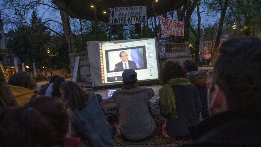Des personnes regardent la retransmission de l'intervention de François Hollande sur France 2, sur la place Granvelle, à Besançon, le 14 avril 2016