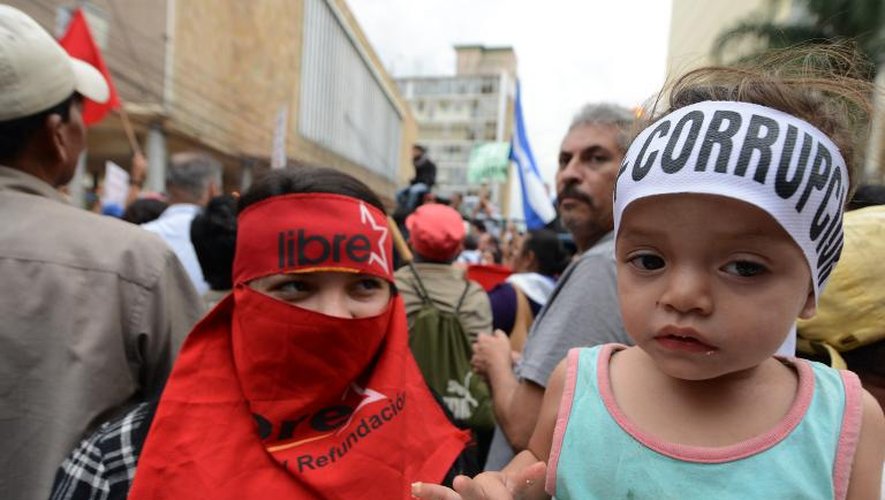 Un enfant porte un bandeau dénonçant la corruption, lors d'une manifestation à Tegucigalpa le 3 juin 2015 pour réclamer la démission du président hondurien Juan Orlando Hernandez
