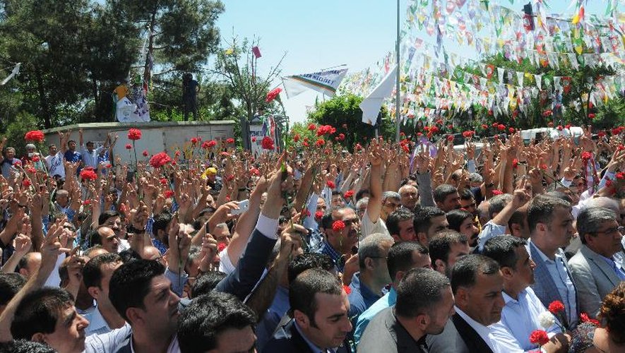 Des personnes manifestent avec des oeillets  à la main le 6 juin 2015, à Diyarbakir au lendemain d'une attaque mortelle contre un parti kurde