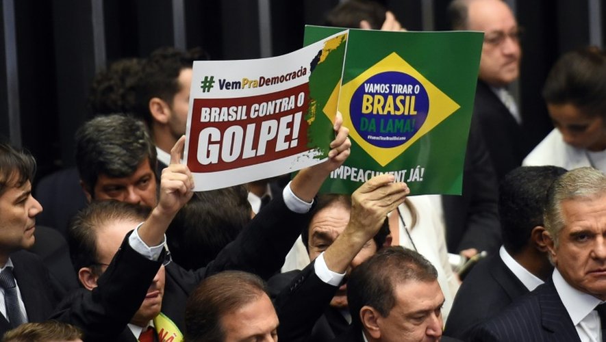 Des députés brésiliens brandissent des signes pour ou contre la destitution de la présidente Dilma Rousseff à la chambre basse du congrès à Brasilia le 17 avril 2016