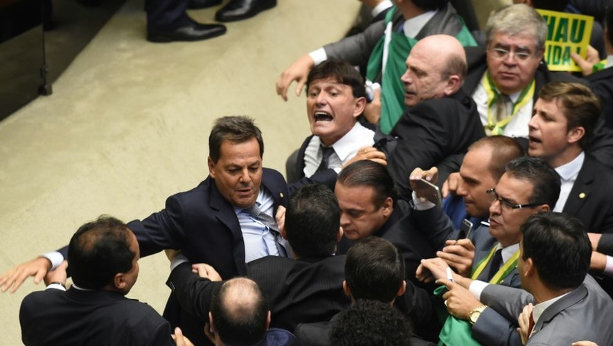 Des députés brésiliens s'accrochent pendant la session historique qui va se prononcer sur la destitution de la présidente Dilma Rousseff à la chambre basse du Congrès à Brasilia le 17 avril 2016