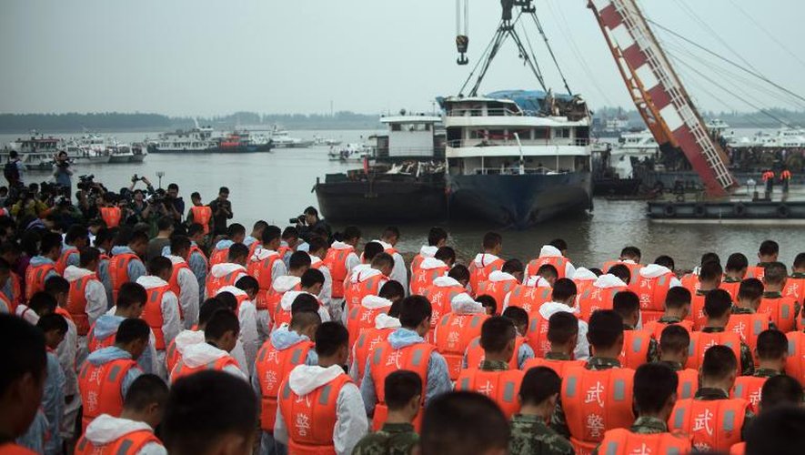 Soldats et secouristes lors de la cérémonie de deuil le 7 juin 2015 sur la berge du Yangtsé, devant l'épave du bateau