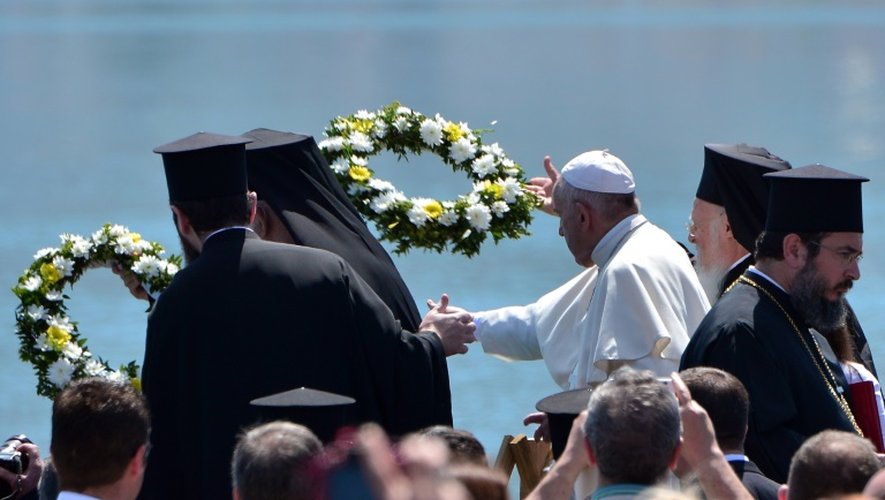 Le patriarche oecuménique Mgr Bartholomée et le pape François jettent à la mer des couronnes de fleurs sur le port de Mytilène, en hommage aux migrants morts en mer, le 16 avril 2016