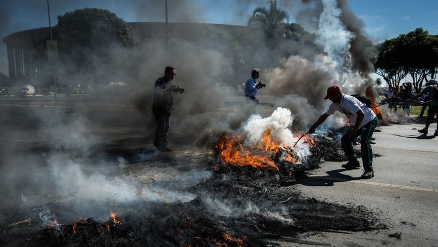 Des manifestants bloquent avec des pneus en flamme l'accès au stade de Brasilia, le 14 juin 2013