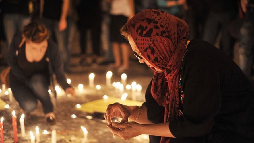 Une femme turque allume une bougie lors d'un rassemblement en hommage aux personnes mortes lors des manifestations place Taksim, à Istanbul, le 14 juin 2013
