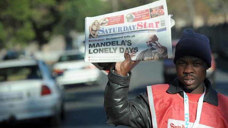 Un vendeur de journaux à Johannesbourg, le 15 juin 2013 brandit le Saturday Star titrant: "Les journées solitaires de Mandela"