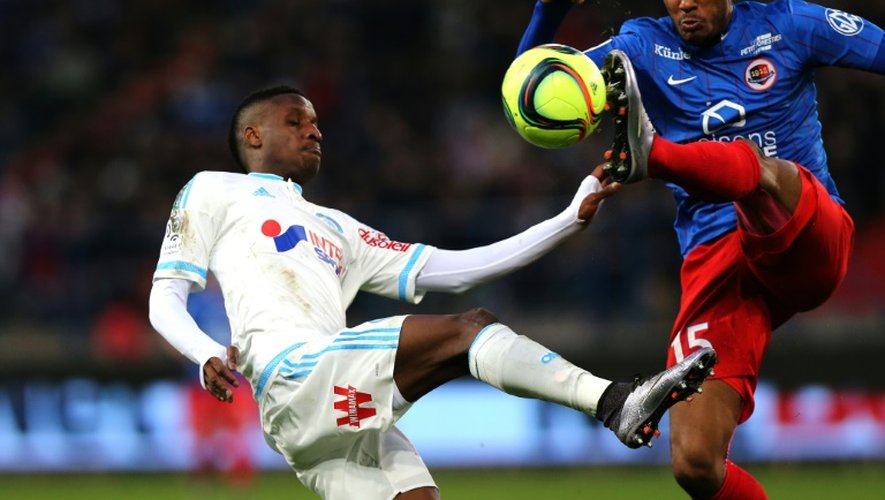 Le milieu de Marseille Bouna Sarr (g) à la lutte avec le défenseur de Caen Emmanuel Imorou au stade Michel d'Ornano, le 17 janvier 2016