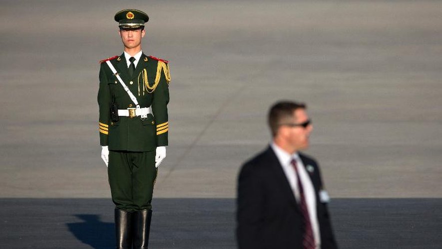 Un agent du Secret Service, au premier plan, sécurise l'aéroport avant l'atterrissage de l'avion transportant la première dame américaine Michelle Obama, à Pékin le 20 mars 2014