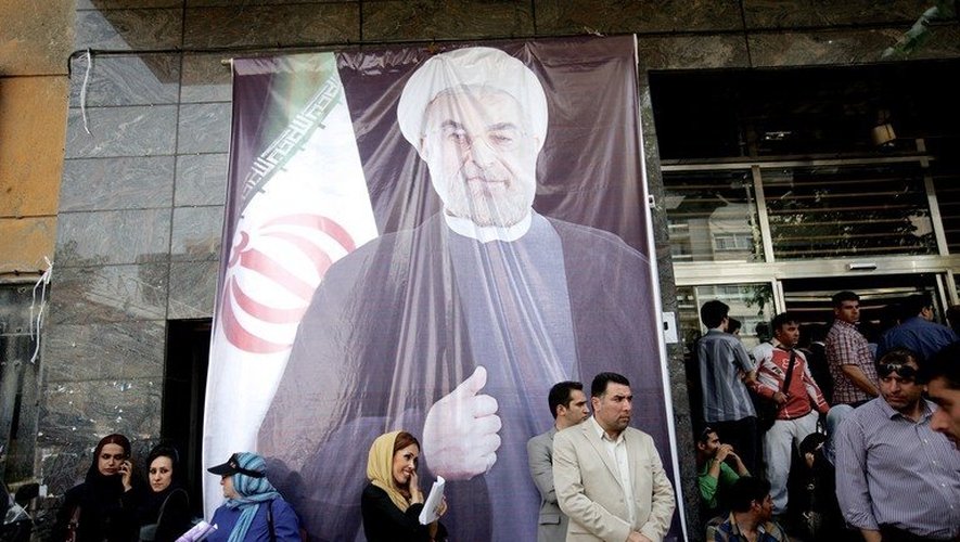 Des Iraniens rassemblés devant un portrait géant de Rohani, le 15 juin 2013 à Téhéran