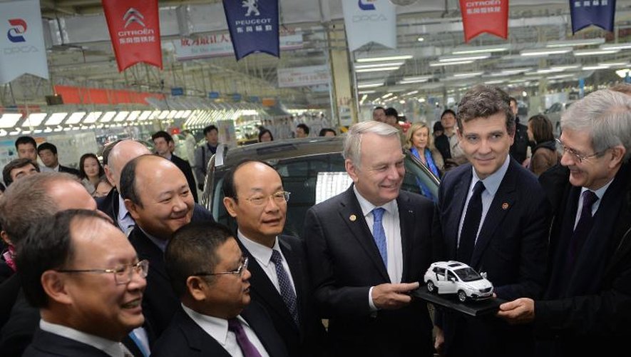Le Premier ministre français Jean-Marc Ayrault (3e d) avec des directeurs chinois dans une usine Dongfeng Peugeot-Citroën Automobile (DPCA) à Wuhan, en Chine le 7 décembre 2013