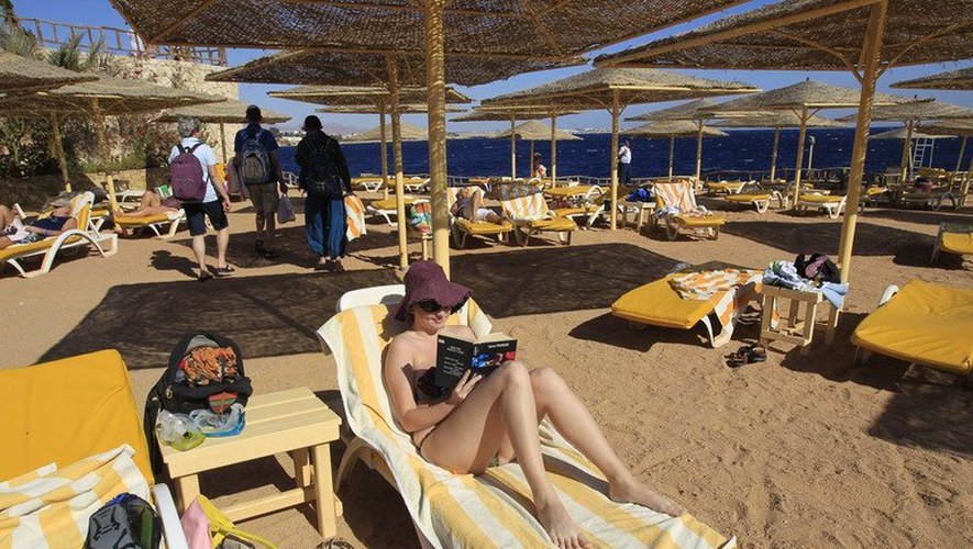 Une femme lit un livre sur une plage