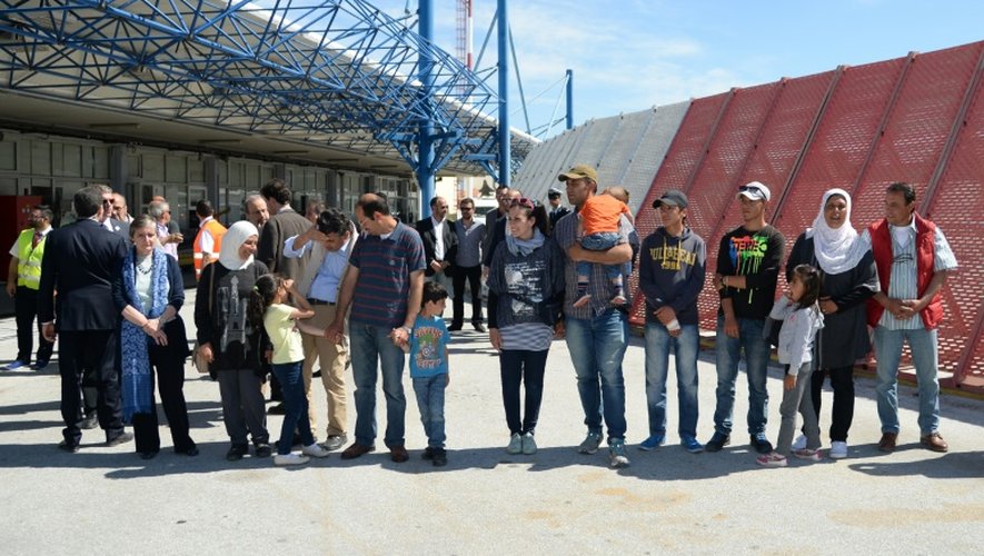 Un groupe de Syriens attendent d'embarquer dans l'avion avec le pape François qui les ramène au Vatican le 16 avril 2016 à l'aéroport de Mytilène sur l'île de Lesbos