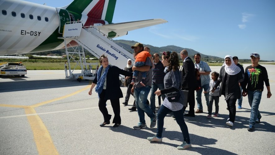 Un groupe de Syriens s'apprêtent à embarquer dans l'avion avec le pape François qui les ramène au Vatican le 16 avril 2016 à l'aéroport de Mytilène sur l'île de Lesbos