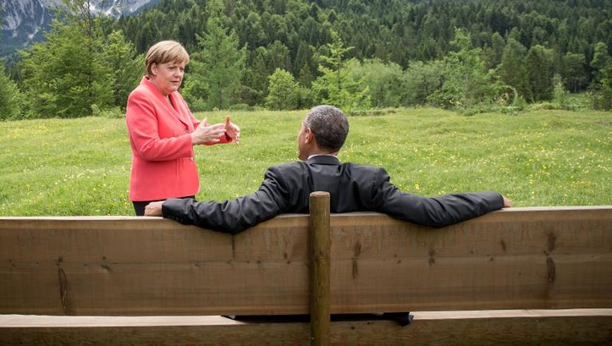 Angela Merkel s'adresse à Barack Obama assis sur un banc dans la propriété du château d'Elmau, lors du sommet du G7 près de Garmisch-Partenkirchen, en Bavière, le 8 juin 2015