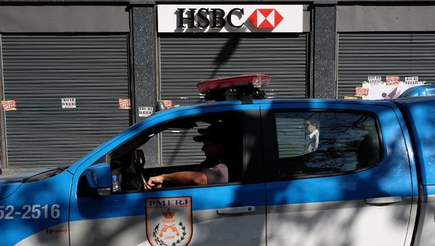 Une voiture de police surveille le 9 juin 2015 une agence d'HSBC à Rio de Janeiro, fermée après l'annonce de la décision de la banque de céder ses opérations au Brésil