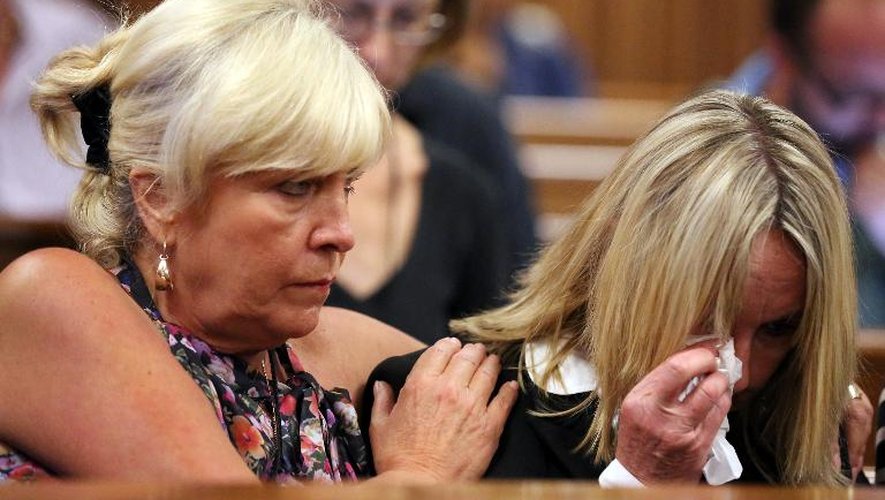 June Steenkamp (droite), la mère de Reeva Steenkamp, et son amie Jenny Strydom, pleure lors du procès d'Oscar Pistorius à Pretoria le 25 mars 2014