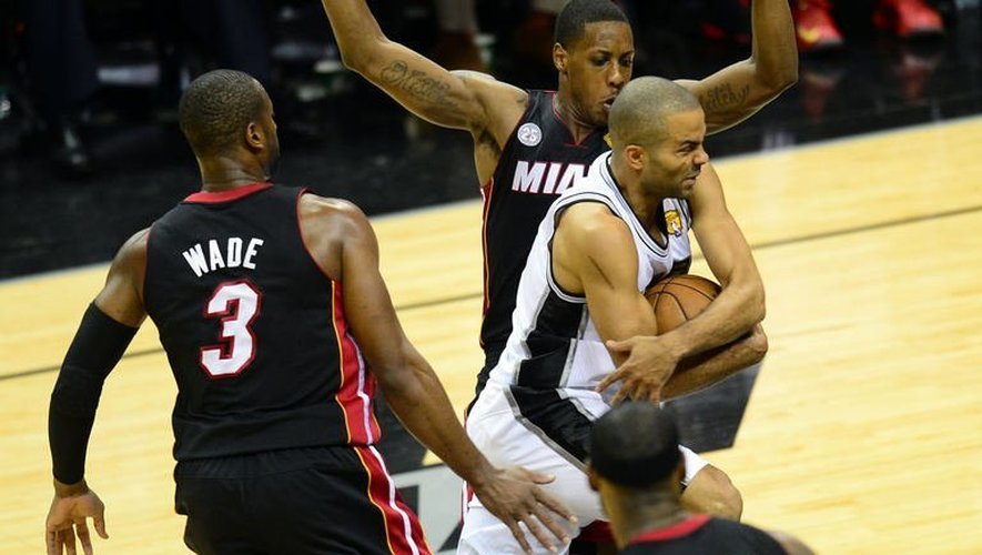 Tony Parker (c) des San Antonio Spurs essaie de passer Dwayne Wade et Mario Chalmers de Miami Heat le 16 juin 2013 à San Antonio