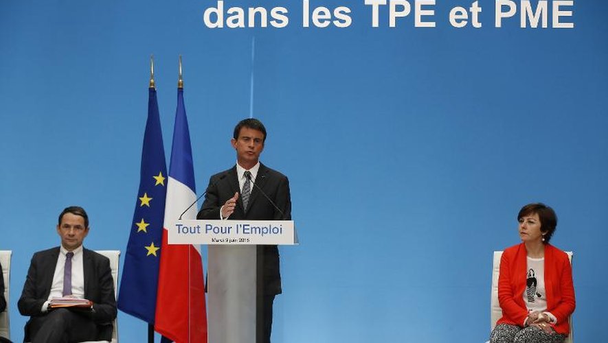 Le Premier ministre Manuel Valls (c) et les secrétaires d'Etat à la Réforme de l'Etat Thierry Mandon (g) et chargée du Commerce, de l'Artisanat, de la Consommation et de l'Économie sociale et solidaire Carole Delga à Paris, le 9 juin 2015