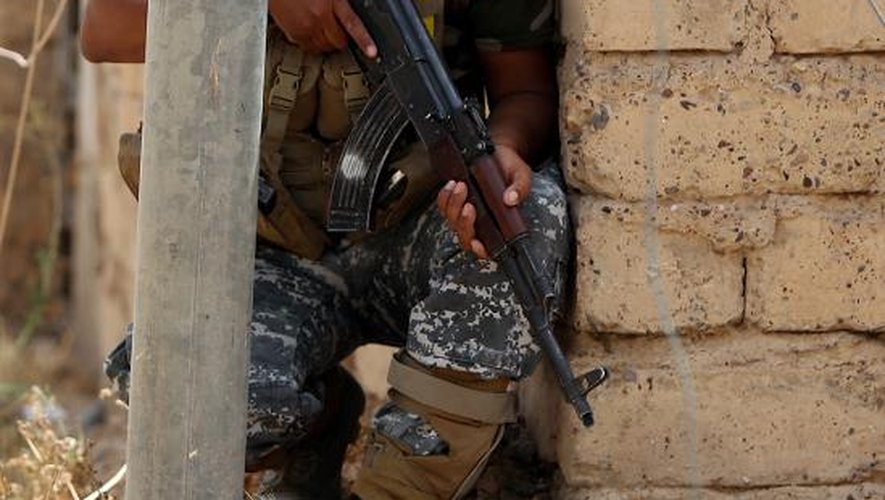 Un combattant chiite irakien affronte des jihadistes du groupe Etat islamique (EI) pour le contrôle de la ville de Baïji, sur l'axe entre Bagdad et Mossoul, le 8 juin 2015