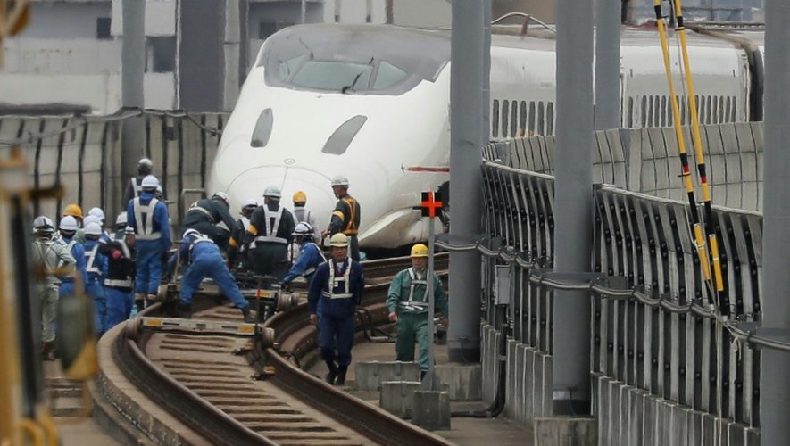 Des ouvriers tentent de remettre en marche un train à grande vitesse shinkansen après son déraillement provoqué par le récent tremblement de terre à Kumamoto, le 18 avril 2016
