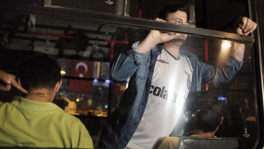 Un homme arrêté le 18 juin 2013 place Taksin à Istanbul emmené dans une voiture de police